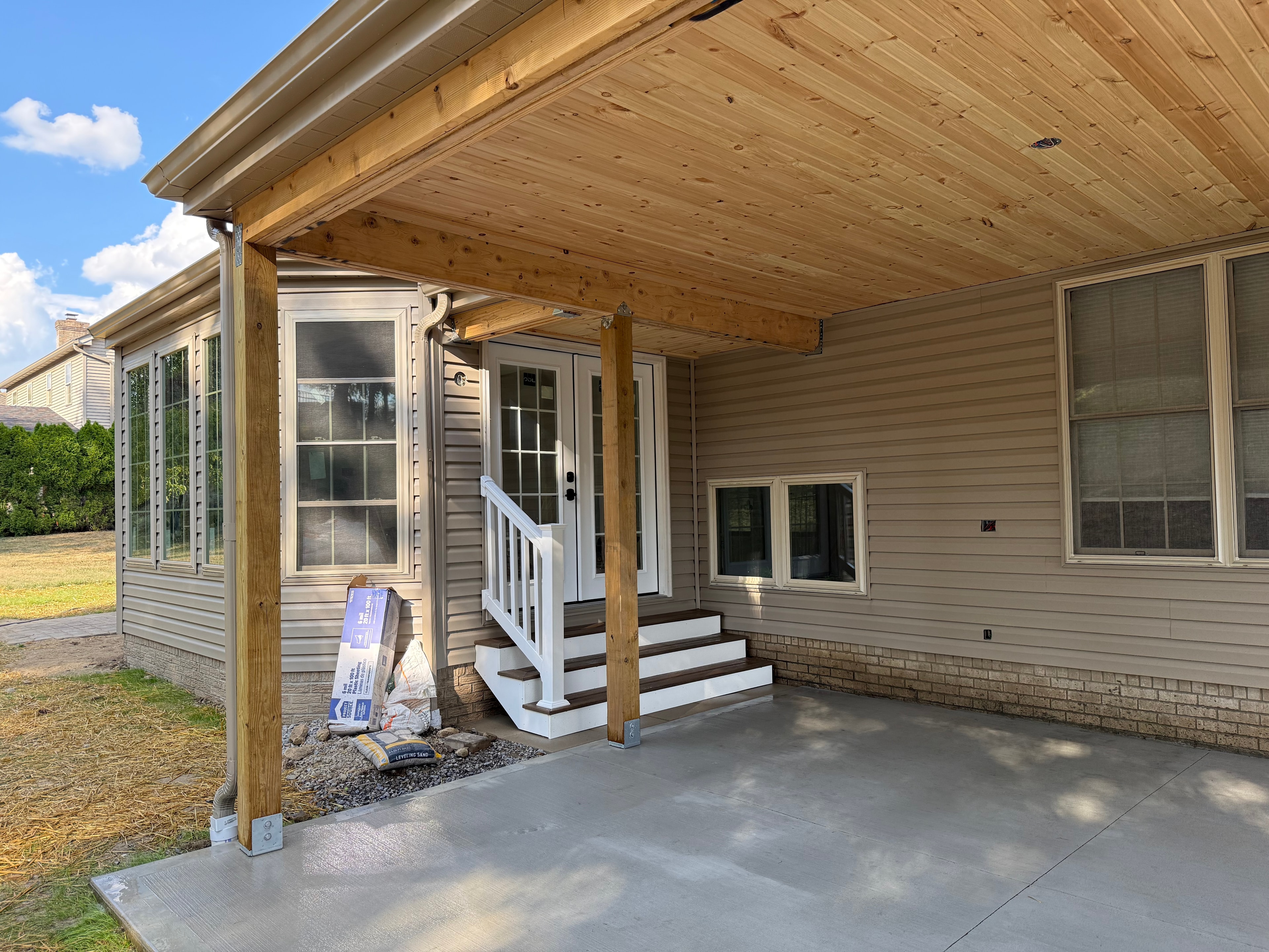 Covered porch addition with wood ceiling and entry steps